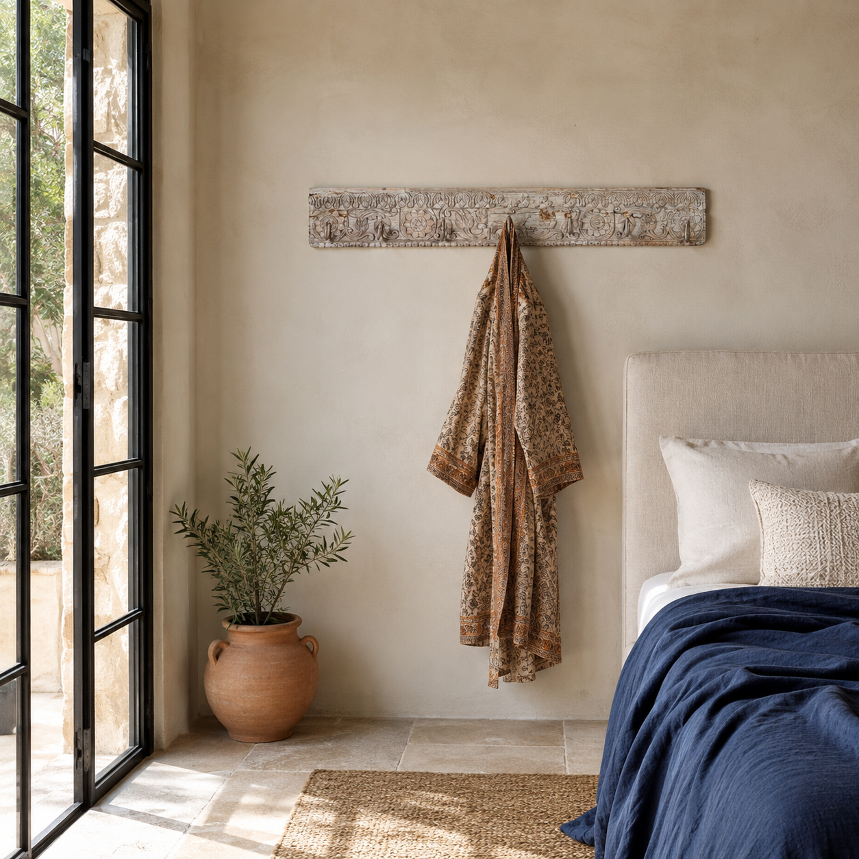 Lifestyle image of a Heritage Hook Rack handcrafted from an antique Indian reclaimed wood architectural element with hand-carved floral details, bleached finish and seven iron hooks, 155x10x5cm.