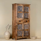 Side view of a hand-carved mango wood cabinet with floral motifs and silver finish – bedroom furniture with rustic charm and artisanal detail.