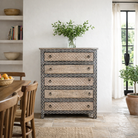 Lifestyle image of a hand painted beige-black wooden chest of 5 drawers in vintage style.