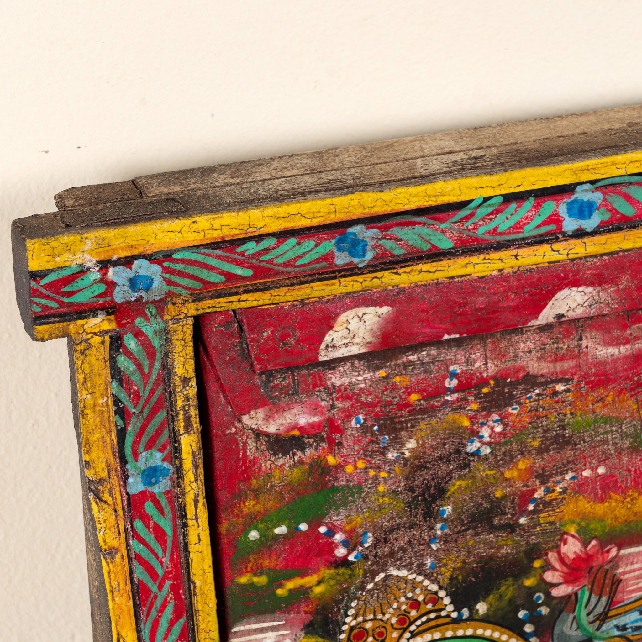 Close up image of a Radha and Krishna antique reclaimed wood mirror with hand-painted Indian artwork on an authentic vintage reclaimed wooden mirror frame, 50x50x5cm.