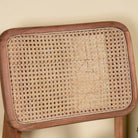 Close up image of an acacia wood chair with woven rattan backrest and solid wooden frame; wooden armchair for dining or living rooms, 45 × 45 × 85 cm.