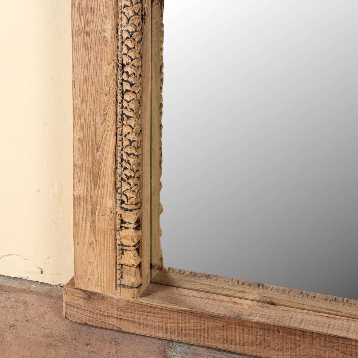 Close up image of a Ishvank reclaimed teak wood mirror made from an old Indian window frame with carved details and arched opening, 87x115cm