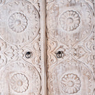 Close up image of a hand carved creme colour mango wood wardrobe wit 2 drawers and 4 shelfs and ample storage.