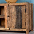 Close up image of a driftwood lowboard made from reclaimed wood with two cabinets, open shelving, and rustic minimalist design, 150 × 40 × 60 cm.