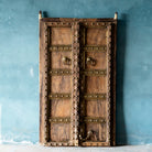 Antique Indian temple door made of old teak with original brass fittings, locks, and ring handles, featuring a richly aged patina from a historic Jain temple.