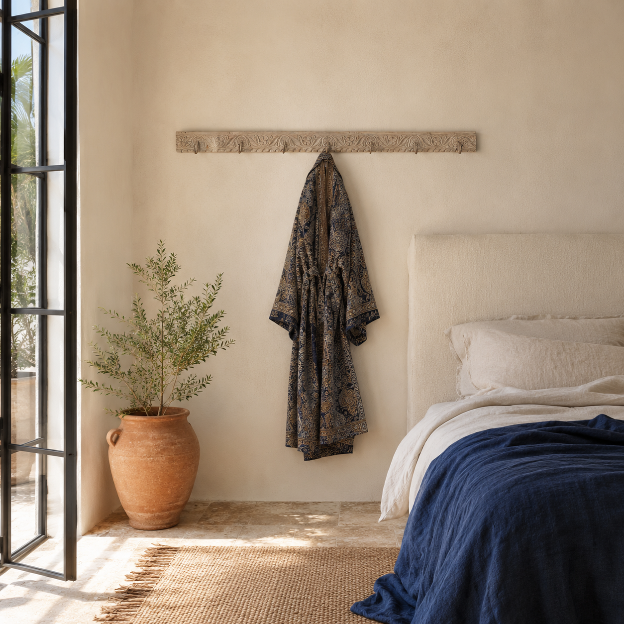 Lifestyle image of a Jaipur Wall Hook Rack handcrafted from an antique Indian reclaimed wood architectural element with hand-carved floral details, bleached finish and seven iron hooks, 150x7x5cm.