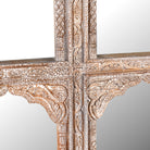 Close up image of a hand-carved wall mirror Jamnagar made from solid mango wood with floral design. A bold piece of Indian furniture online blending craftsmanship and natural beauty.