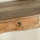 Close up image of a desk made of natural mango wood with 2 drawers and carved legs.