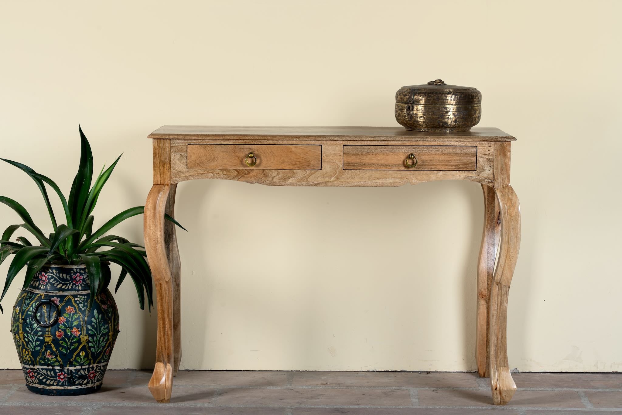 Image of a desk made of natural mango wood with 2 drawers and carved legs.