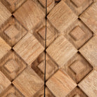 Close up image of a tall mango wood cabinet in grey sandblasted finish with geometric sunburst design and brass handles, 76 × 38 × 135 cm.