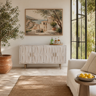Lifestyle image of a whitewashed mango wood sideboard with raised criss-cross design, four doors, and silver metal legs—elegant living room furniture with modern rustic appeal.