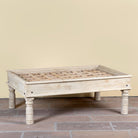 Jayson reclaimed teak wood coffee table with glass top, removable legs, and hand carved antique Indian ceiling panel.