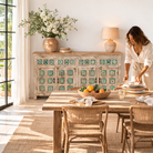 Lifestyle imagination of a hand-carved mango wood sideboard with green floral accents and vintage finish; perfect for bedroom furniture and bohemian interior style, 180 × 100 × 40 cm.