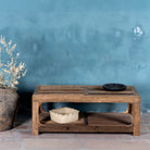 Front view of a driftwood coffee table made from reclaimed wood with rustic finish and open lower shelf; sustainable furniture, 120 × 60 × 40 cm.