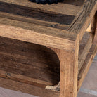 Close up view of a driftwood coffee table made from reclaimed wood with rustic finish and open lower shelf; sustainable furniture, 120 × 60 × 40 cm.