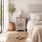 Lifestyle inspiration of a hand carved mango wood night stand with rattan inserts; sustainable bedroom furniture, 67 × 47 × 40 cm.