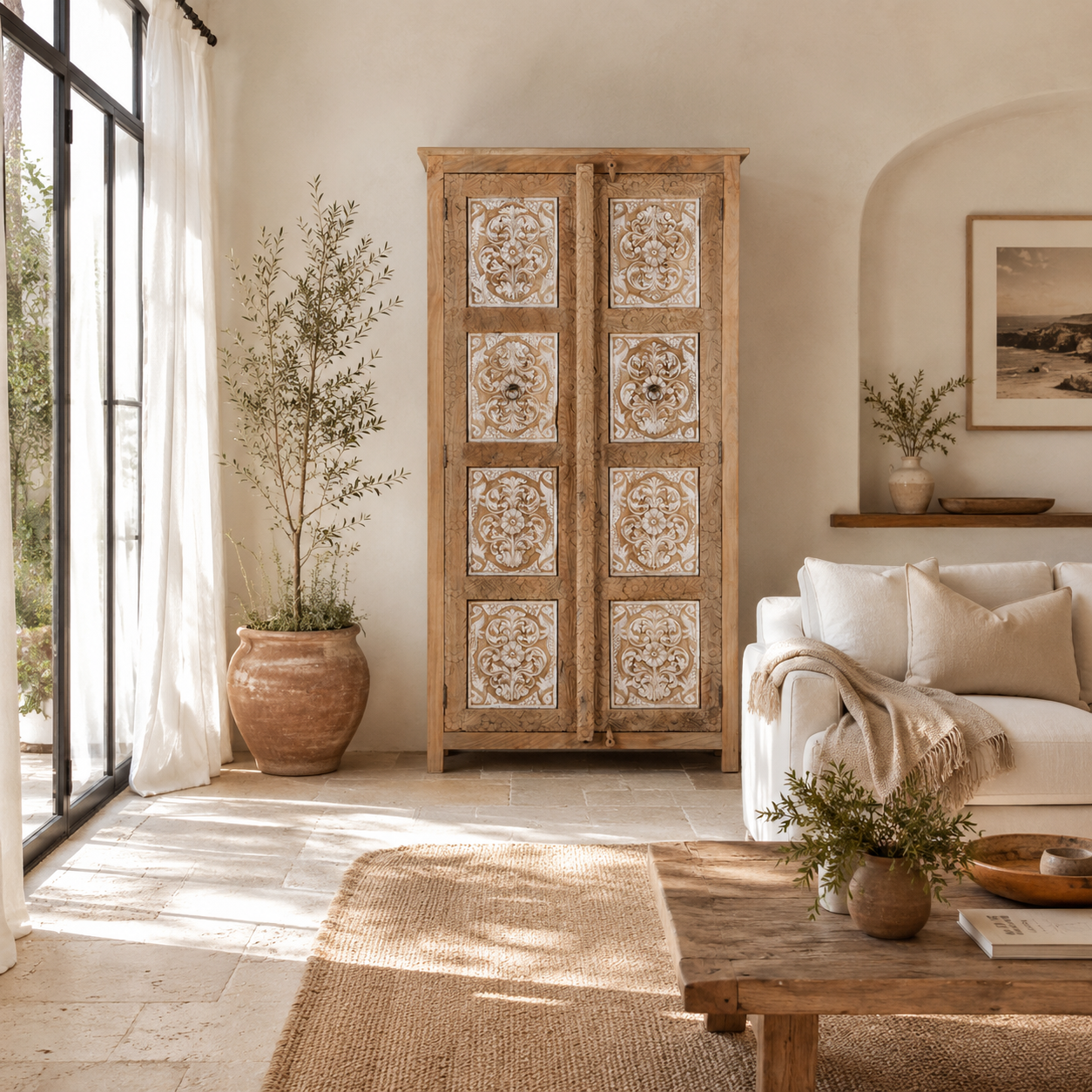 Lifestyle image of a hand carved wooden wardrobe made of solid mango wood with whitewashed floral details; Ibiza-style mango wood wardrobe, 190 × 100 × 40 cm.