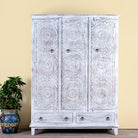Image of a white washed hand carved wardrobe made of mango wood in floral design with 2 drawers and ample inside storage.