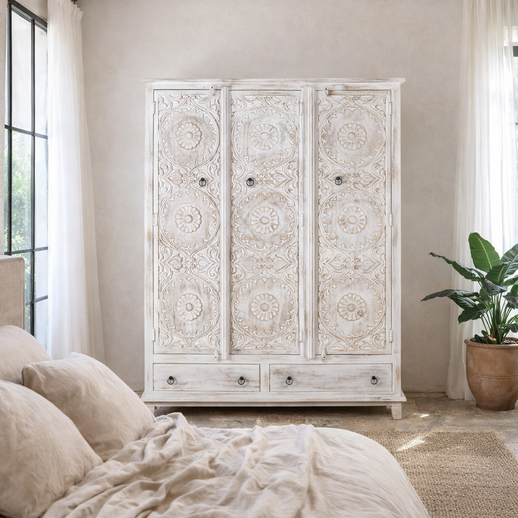 Lifestyle image of a white washed hand carved wardrobe made of mango wood in floral design with 2 drawers and ample inside storage.