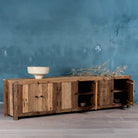 Side angle image of a sustainable driftwood furniture lowboard made from reclaimed wood with four cabinets and rustic finish; 230 × 45 × 60 cm.