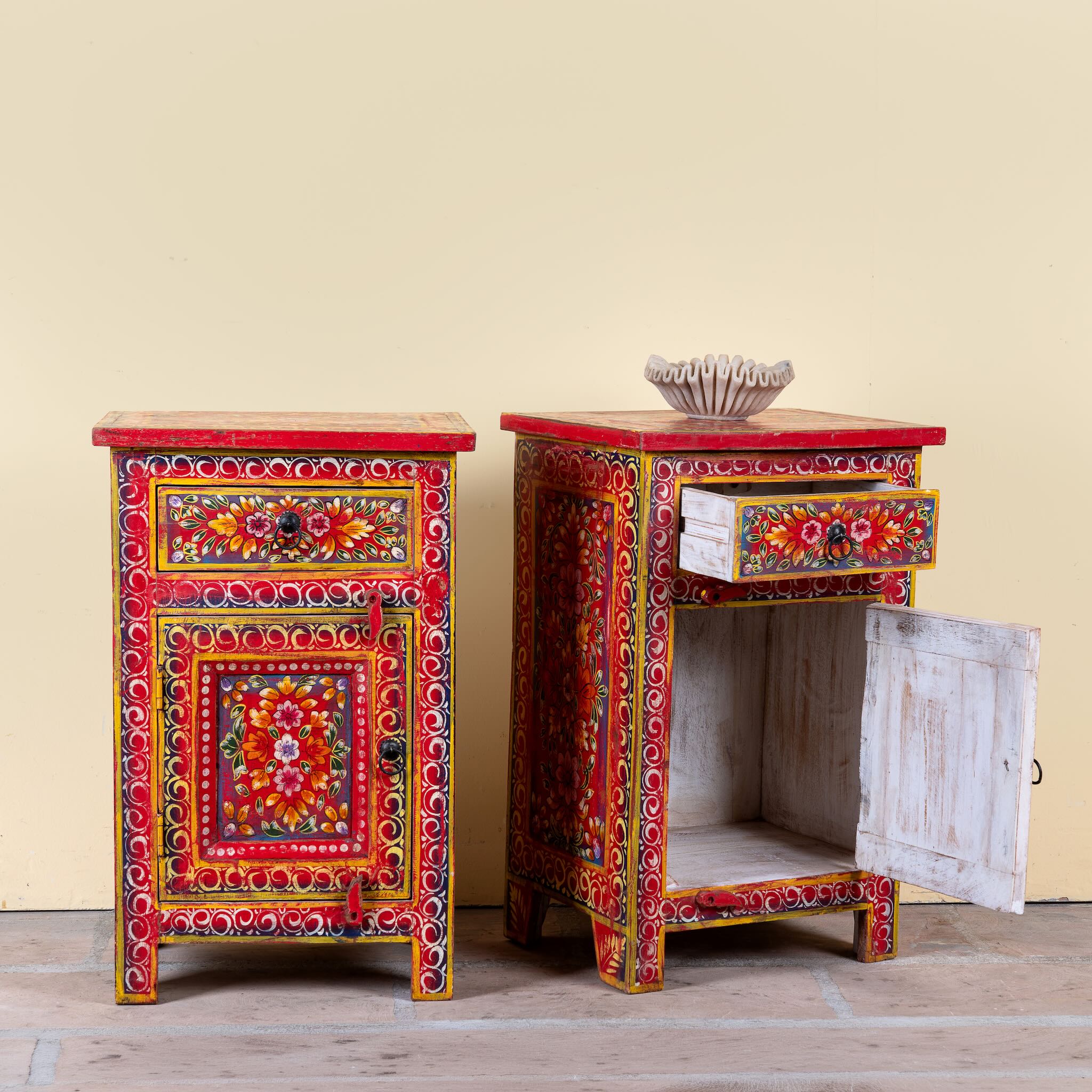 Side angle image with open door of a Joven pair of hand painted reclaimed wood nightstands with one drawer, one cabinet door, floral artwork, and vibrant red boho style finish.