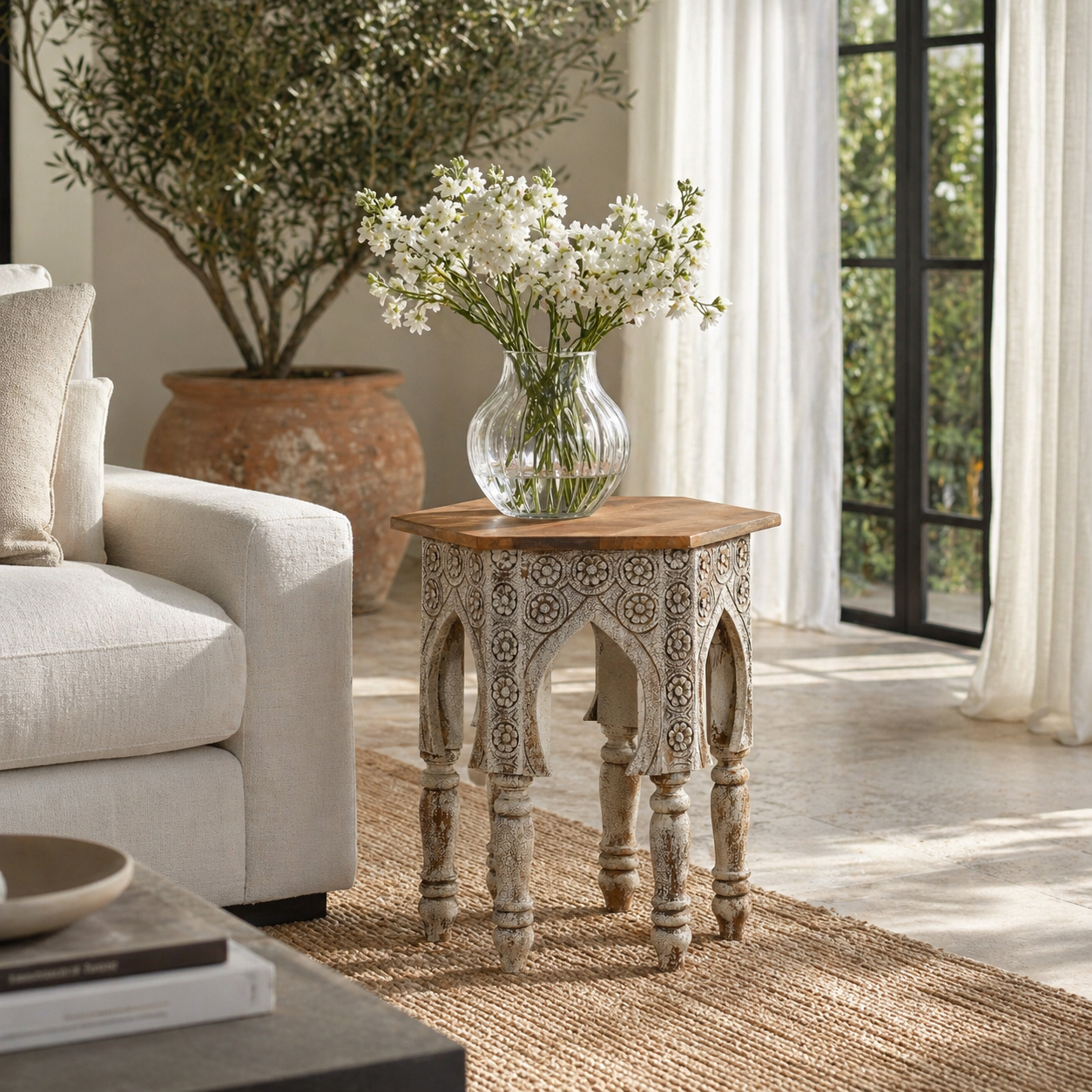 Lifestyle image with a hand carved mango wood coffee table with floral pattern, striking layered colour and vintage charm. A unique wooden accent for your home.