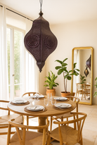 Lifestyle scene of a hand-punched oriental metal pendant lamp Kairav in antique finish – 80 cm tall decorative lighting with intricate perforations, ideal for cosy ambient light.