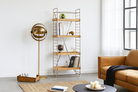 Lifestyle image of a compact brass-plated iron shelf with removable mango wood trays – minimalistic furniture and modular mango wood shelving for stylish, functional interiors.