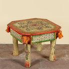 Side angle image of a Kaliana hand-painted reclaimed wood coffee table with sculpted tiger heads and colourful floral design 80cm