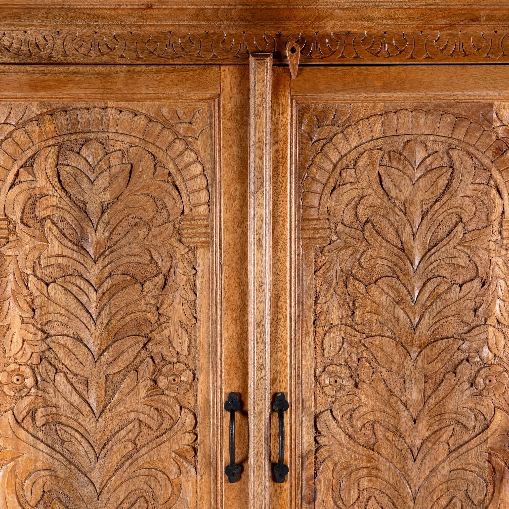 Close up image of a Kalki hand carved mango wood wardrobe with botanical carved doors, removable shelves and hanging rail, 110x56x190cm