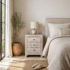 Lifestyle image with a hand carved night stands in solid mango wood with mandala motifs; white washed furniture, 50 × 40 × 60 cm.