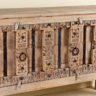 Wooden cabinet with intricate carvings on a light background