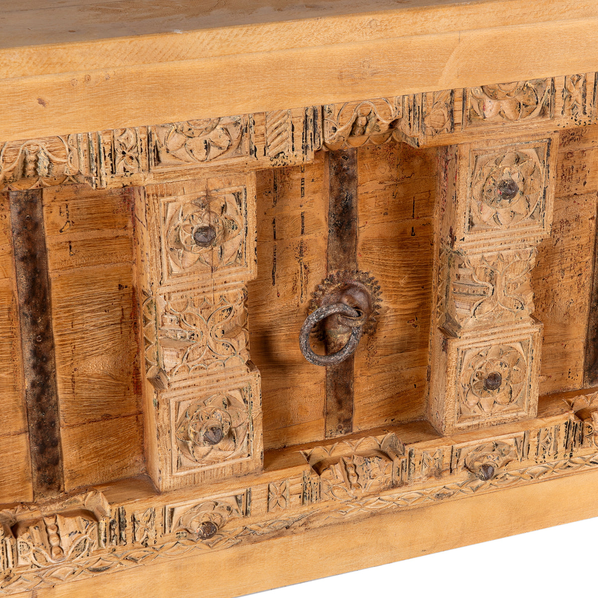 Close up image of a Kanan console table made from old teak door panels, featuring traditional hand-carved details, iron ring accents, and built-in storage in a natural rustic finish.