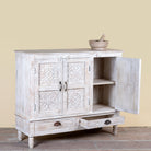 Side angle image with open doors of a whitewashed hand carved wooden sideboard made from solid mango wood with floral patterns, 3 doors and 2 drawers; artisanal mango wood furniture, 120 × 100 × 40 cm.