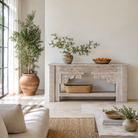 Lifestyle image of a of a Karam reclaimed teak console table with hand-carved Indian details, lower shelf, and vintage whitewashed finish.