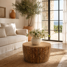 Lifestyle image of a round mango wood coffee table with hand-carved detailing and natural finish; rustic carved coffee table, 90 cm diameter, 52 cm height.