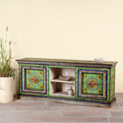 Side angle image of a hand-painted reclaimed wood vintage lowboard with floral motifs – a colourful piece of sustainable furniture for artistic and rustic interiors.
