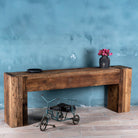 Side angle image of a rustic minimalistic console table made from reclaimed wood with preserved imperfections, block legs, 250 × 40 × 90 cm.