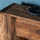 Close up image of a rustic minimalistic console table made from reclaimed wood with preserved imperfections, block legs, 250 × 40 × 90 cm.