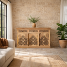 Lifestyle image of a hand-carved mango wood sideboard Kaveri with 6 compartments and 3 drawers, oriental-inspired mango wood furniture, 150 × 90 × 40 cm.