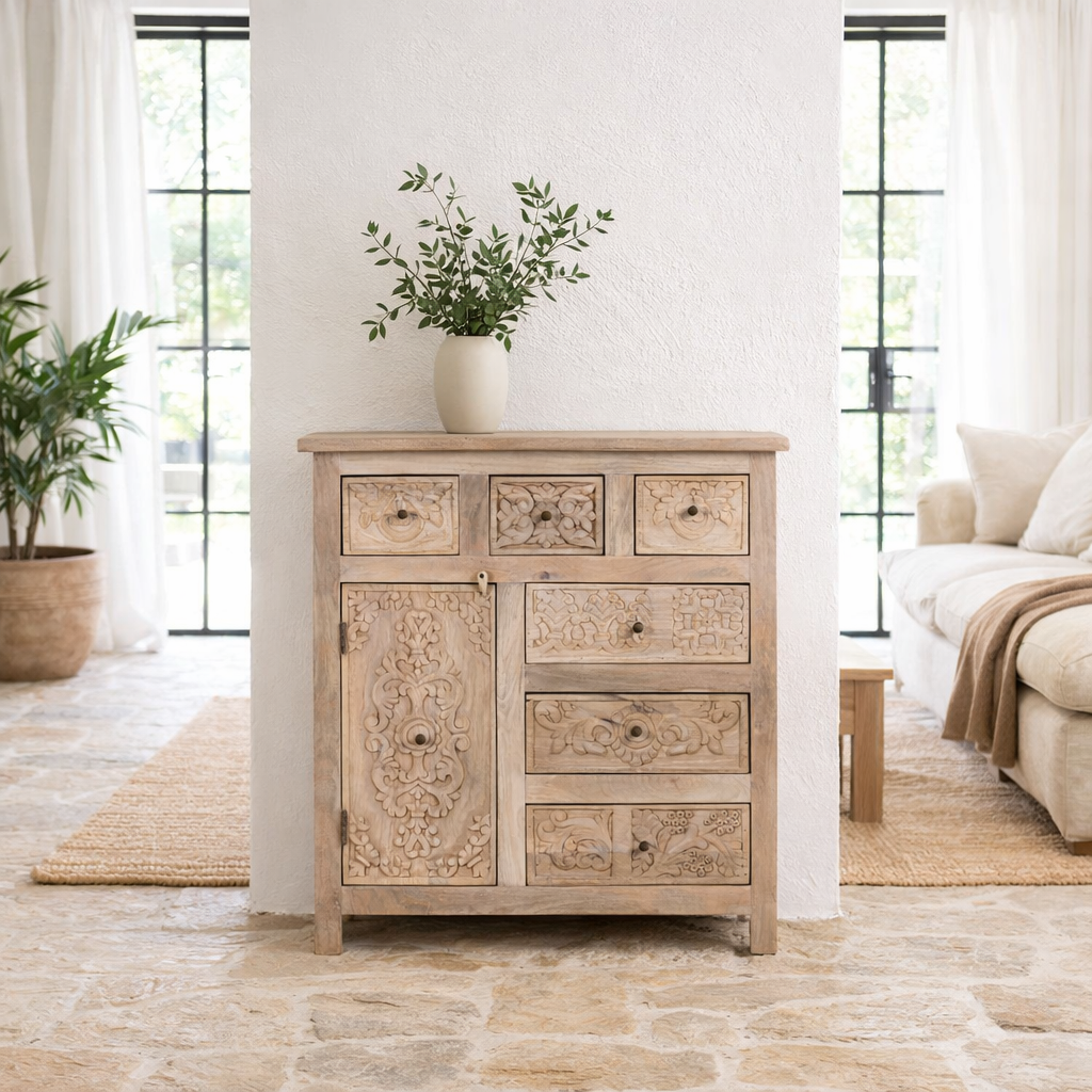 Lifestyle imagination of a hand carved mango wood cupboard with 6 drawers and 1 door, iron fitted door knobs and floral carvings.