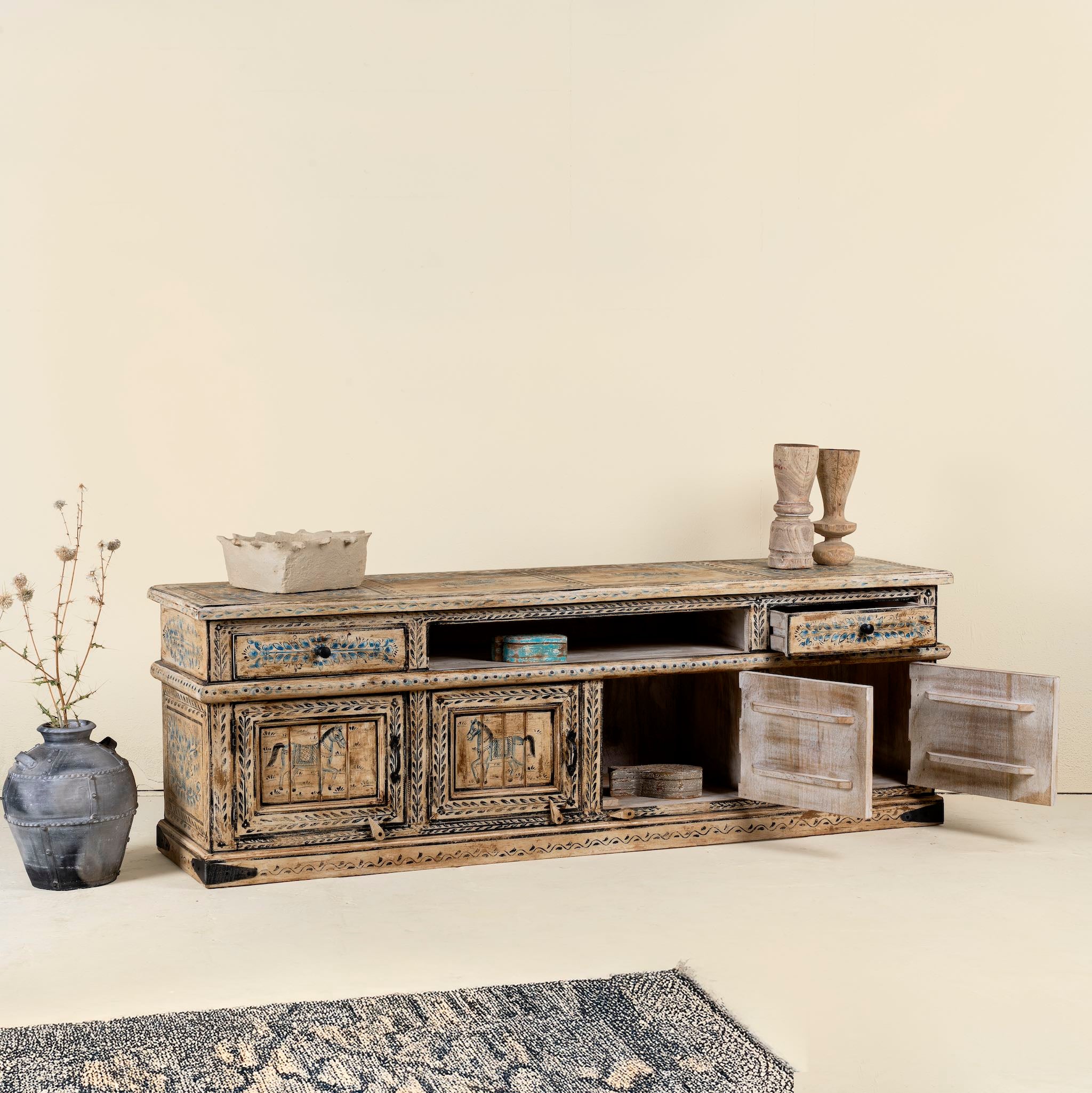 Side Angle image with open door of a hand painted TV unit in reclaimed wood with Indian elephant and horse motifs, drawers and cabinets, 180 × 45 × 60 cm.