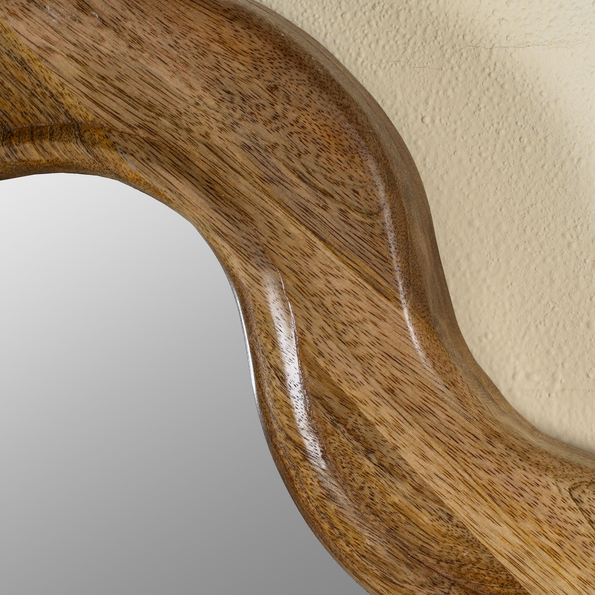 Close up image of a wavy round mango wood mirror Khavda with scalloped frame design. A bold wall decoration and artisan-crafted statement piece for bohemian, rustic, or modern interiors.