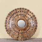 Round mango wood mirror Kiaan with concentric carved design and mirror inlays. A piece of unique wall decor combining artisanal craftsmanship and rustic bohemian charm.