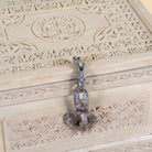Close up image of a Kiara hand carved reclaimed wood storage box with bleached finish, antique iron lock and side carrying handles, 50x40x33cm.