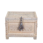 A rectangular carved wooden chest with a distressed light beige finish, featuring intricate floral engravings on the front and lid, a decorative metal latch, and small feet at the bottom, shown on a plain white background.
