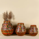 Set of 3 hand-painted decorative iron pots in orange tones with traditional Indian floral and paisley motifs – ideal for vintage home accessories and painted iron decoration.