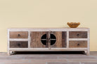 Kishen handcrafted reclaimed wood lowboard with driftwood front detailing, carved cabinet doors, four drawers, and natural rustic boho style finish.