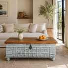 Lifestyle image of a antique Indian chest coffee table in blue with brass fittings – solid teak iron fitted wooden chest repurposed as living room table with storage.