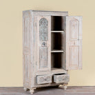 Side angle image with open doors of a Kyra antique reclaimed teak wood wardrobe with intricate Indian hand carvings, double doors, and vintage distressed finish.